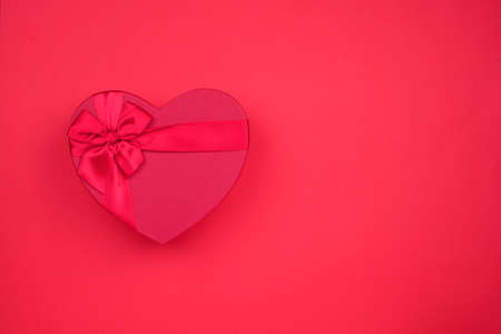 Red big heart-shaped gift for Valentine's Day on a red background.の写真素材