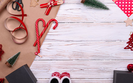 Gift wrapping. Packaging modern christmas present boxes in stylish gray paper with satin red ribbon. Top view table with fir tree branches, decoration of gift.の写真素材