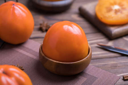 Delicious fresh orange persimmon fruit on wooden tableの写真素材