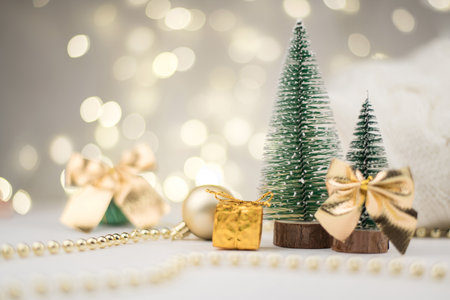 decorative Christmas trees decorated and gifts for the new year on the background of Golden bokeh lights, new year background, new year mood 2021.の写真素材