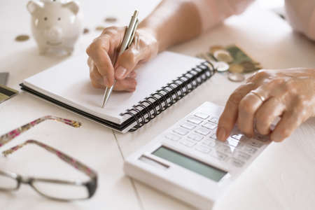 Old women's hands count expenses, plan a budget the concept of retirement, savings, old ageの写真素材