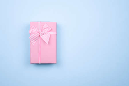Gift rectangular pink box with bow on a pure blue background.の写真素材