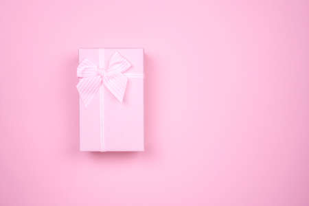 Gift rectangular pink box with bow on a pink background.の写真素材