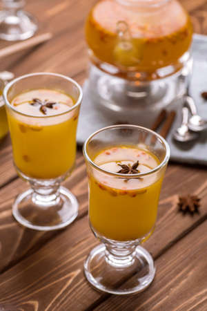 Beautiful glass teapot with sea buckthorn tea. Hot winter drinks.の写真素材