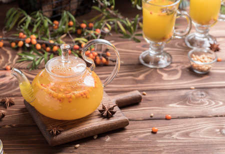Beautiful glass teapot with sea buckthorn tea. Hot winter drinks.の写真素材