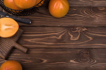 Delicious ripe persimmon fruit on wooden background.の写真素材