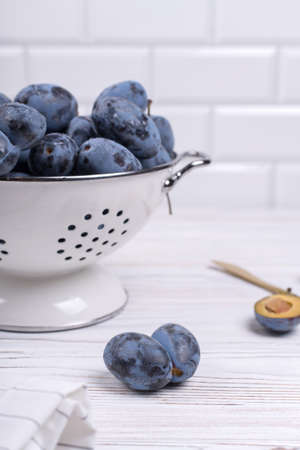 Lots of ripe juicy plums in a bowl on the table.の写真素材