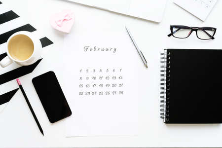 14 February calendar on work space with pink gift heart Valentine's Day card, cup of cofe.の写真素材