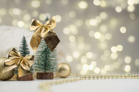 decorative Christmas trees decorated and gifts for the new year on the background of Golden bokeh lights, new year background, new year mood 2021.の写真素材