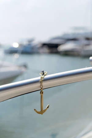 sea Golden anchor on the background of blured yachts in the sea in the sun, defocusedの写真素材