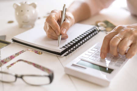 Old women's hands count expenses, plan a budget the concept of retirement, savings, old ageの写真素材