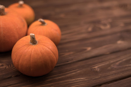 Autumn small orange pumpkin on a wooden table, the harvest, the symbol of Halloween.の写真素材