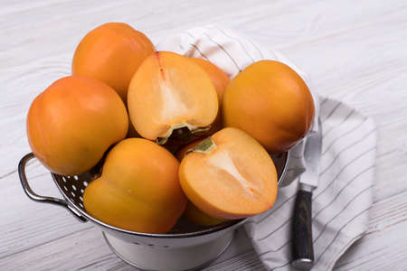 Delicious ripe persimmon fruit on wooden background.の写真素材