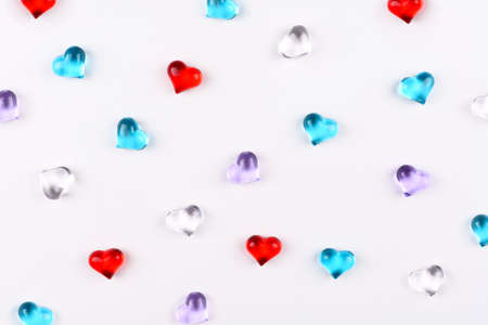 A scattering of colored glass hearts on white background for Valentine's Dayの写真素材