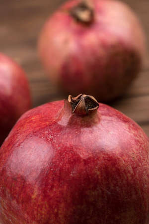 The fruit of a round ripe pomegranate on a dark background.の写真素材