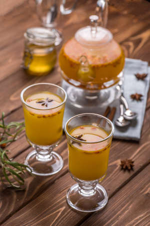 Beautiful glass teapot with sea buckthorn tea. Hot winter drinks.の写真素材