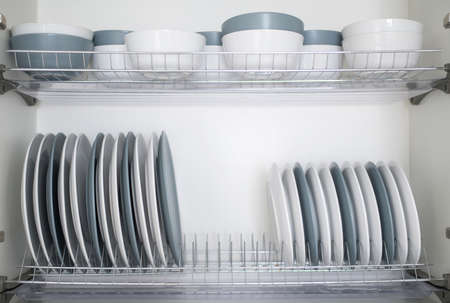 White and gray plates are stacked for storage in the kitchenの写真素材