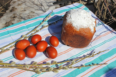 Photo Spring Easter cake on the table, painted eggs and willow branches.