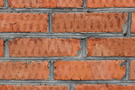 Photo texture of the old cracked red brick with seams