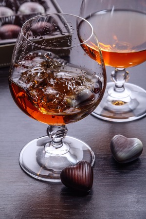 Splash of brandy in glass on wooden tableの写真素材