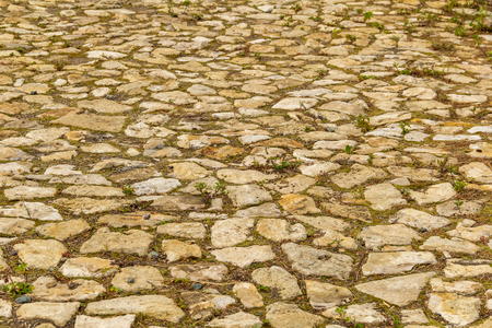 Fragment an ancient winding road paved with cobblestones and overgrown with grass.の写真素材