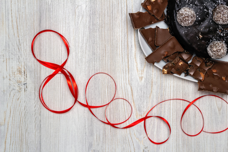 Chocolate cake and number eight made from red ribbon on the wooden table. Happy Women's Day Conceptの写真素材