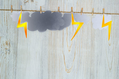 Bad weather, thunderstorms concept. Clouds and zips of paper are attached with clothespins. Flat...