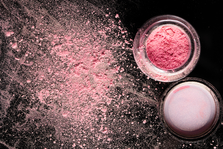 Pink eyeshadow in open jar on dark backgroundの写真素材