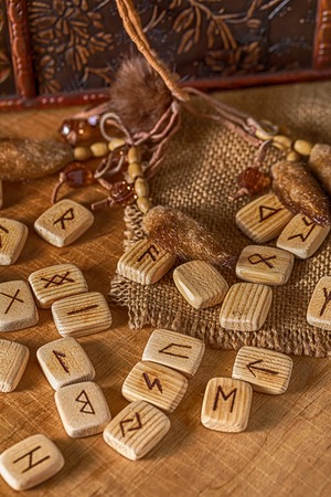 Handmade scandinavian wooden runes on a wooden vintage background. Concept of fortune telling and prediction of the future.の写真素材