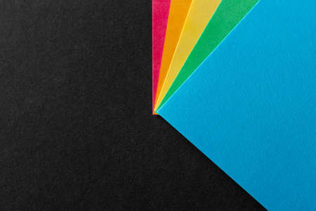 Colored rainbow paper corners on black textured background. Business concept. Layout for design. Copy space. High quality photoの写真素材