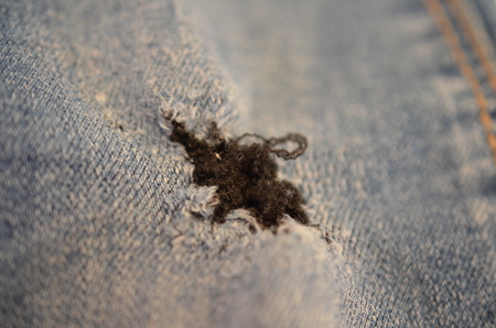 blue texture maden from a piece of jeans with torned hole with threads blurred tonedの写真素材