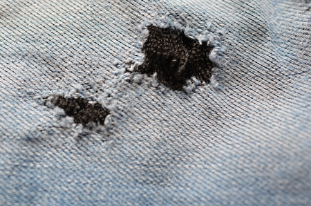 blue texture maden from a piece of jeans with torned hole with threads blurred tonedの写真素材
