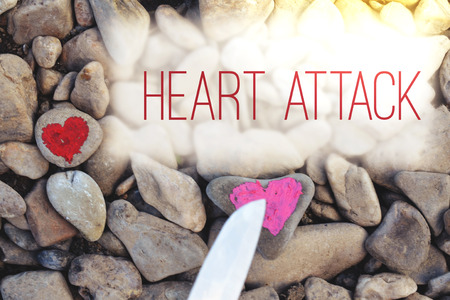 Cutting knife diving pink heart painted with lipstick on piece of stone. Symbol of the end of love and of two people break up and divorce with text letter Heart attackの写真素材