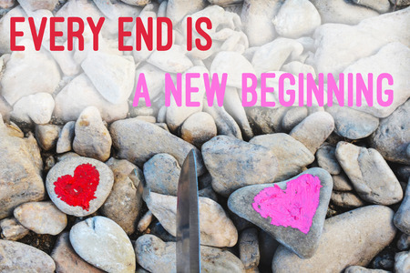 Cutting knife diving pink heart painted with lipstick on piece of stone. Symbol of the end of love and of two people break up and divorce with text letter Every end is new beginningの写真素材
