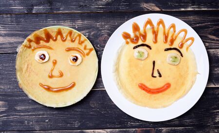 Two pancakes with smile for kids on wooden backgroundの写真素材