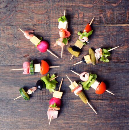 skewers of salmon , shrimps, cheese, sausage and vegetablesの写真素材