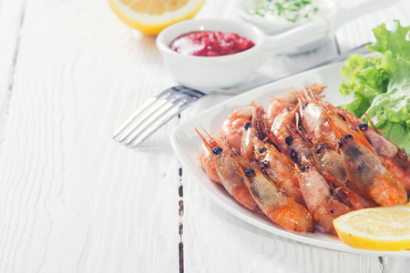 Fried shrimp with lemon & salad on wooden backgroundの写真素材