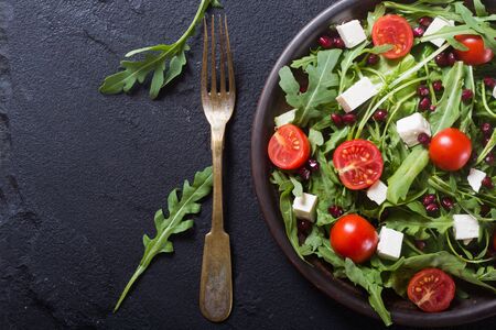 Fresh spring salad with rucola , feta cheese , tomatoes and pomegranate seedsの写真素材