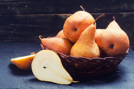 Pears in basket on black stone backgroundの写真素材
