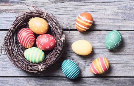 easter eggs in nest on rustic wooden background