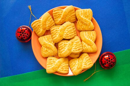 The photo of a pile of  cookies or shortcake biscuits on the plate with red bells.  National Cookie...