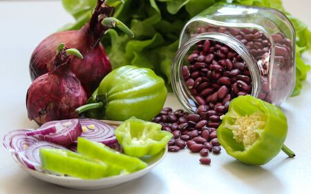 Still life with red beans, red onion, green pepper and saladの写真素材