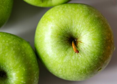 juicy green apples on a white plate close upの写真素材