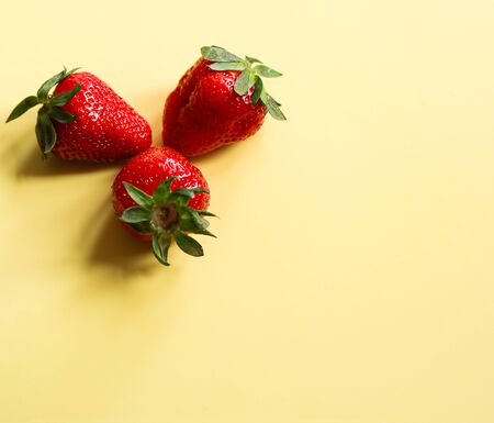 isolated ripe strawberries on a yellow background close upの写真素材