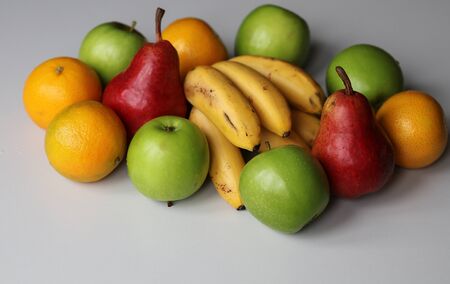 ripe bananas, pears, apples and oranges on a white background close-upの写真素材