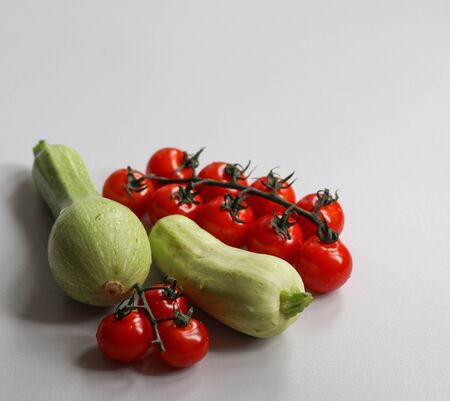 fresh zucchini and cherry tomatoes on a white background close upの写真素材