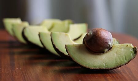 avocado slices on a wooden board close up
