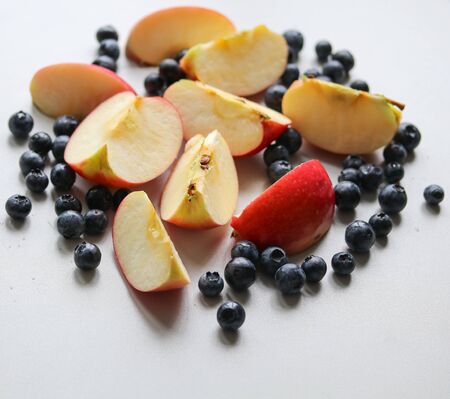 ripe juicy blueberries and sliced apples on a white background macro photoの写真素材