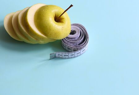 sliced apple and measuring tape on a light background close upの写真素材