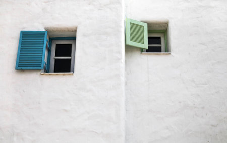 Two open greek windows on the old wall